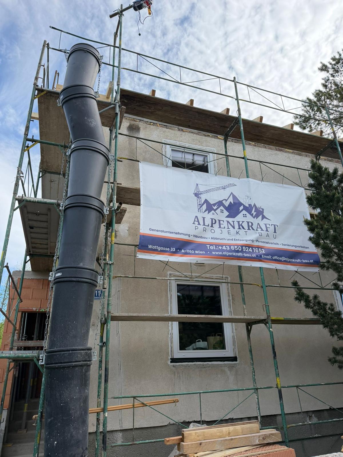 Baustelle der Baufirma Alpenkraft in Langenzersdorf mit Gerüst und Firmenbanner